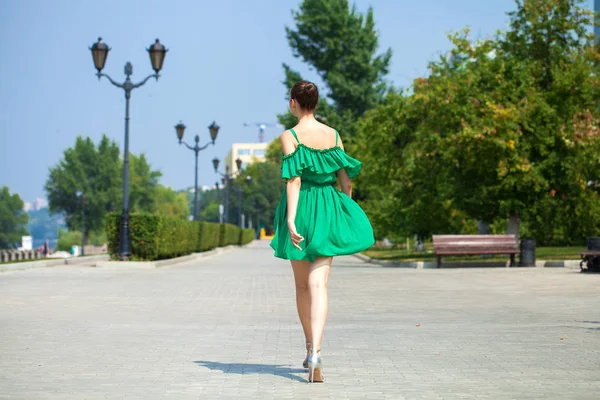 Jonge mooie brunette meisje in groene jurk wandelingen langs de EMB — Stockfoto