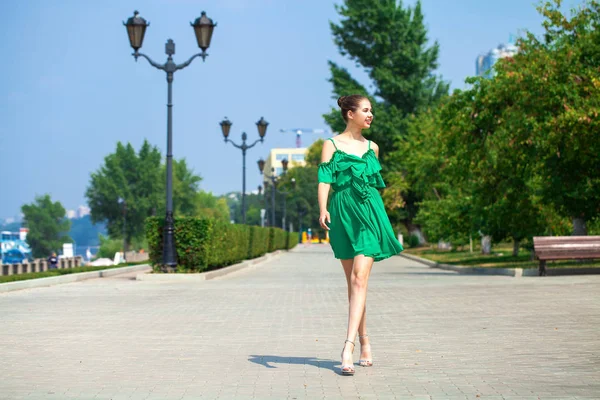 Jovem mulher bonita em vestido verde andando sobre a árvore de verão — Fotografia de Stock