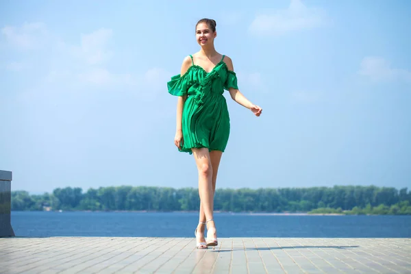 Jovem mulher bonita em vestido verde andando sobre a árvore de verão — Fotografia de Stock