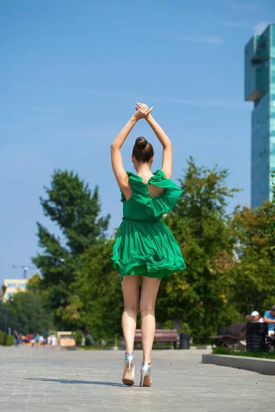 Giovane bella ragazza bruna in abito verde cammina lungo l'emb — Foto Stock