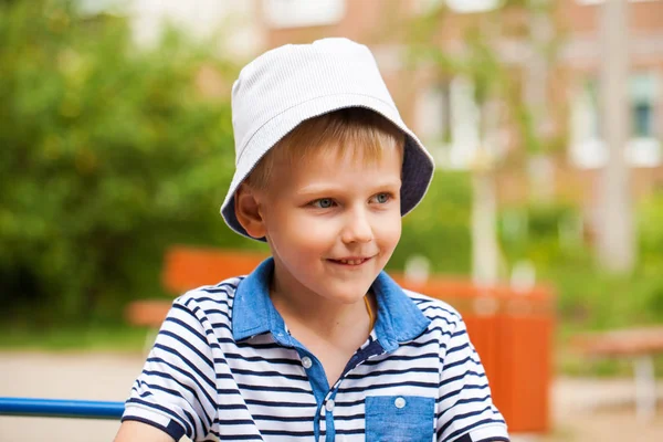 Portret van een kleine blonde jongen in een blauwe hoed — Stockfoto