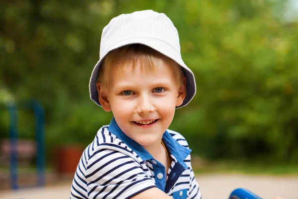 Portret van een kleine blonde jongen in een blauwe hoed — Stockfoto