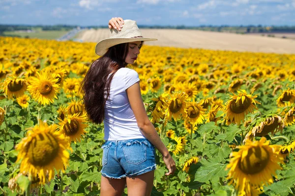 Retrato de uma jovem menina bonita em um campo de girassóis — Fotografia de Stock