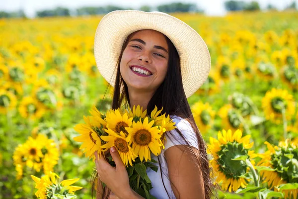 Młoda piękna kobieta w słomkowym kapeluszu i z bukietem kwiató — Zdjęcie stockowe