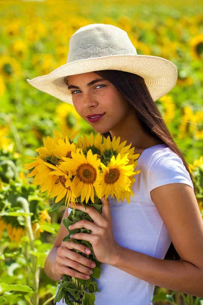 Retrato de uma jovem menina bonita em um campo de girassóis — Fotografia de Stock