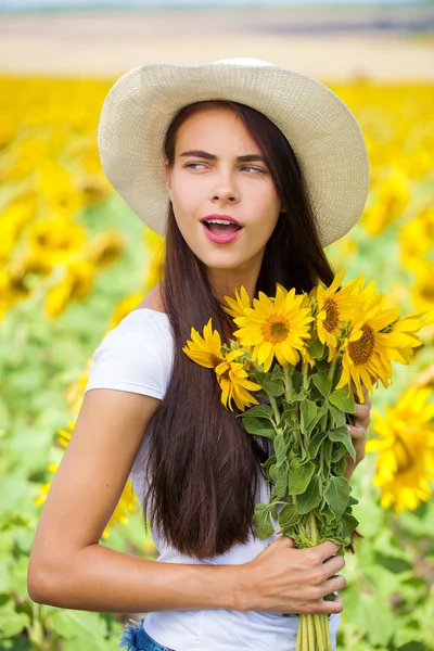 Retrato de uma jovem menina bonita em um campo de girassóis — Fotografia de Stock