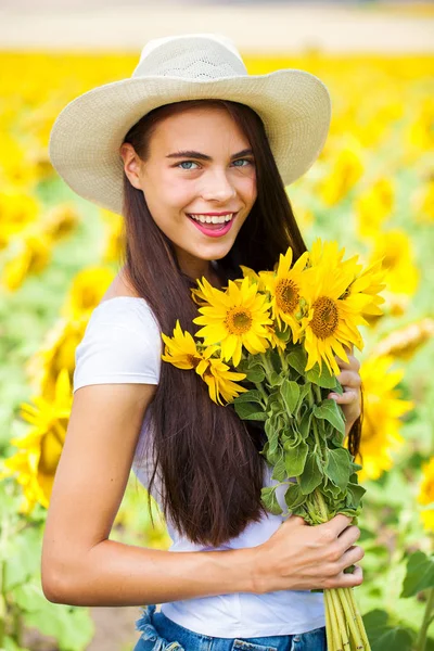 Retrato de uma jovem menina bonita em um campo de girassóis — Fotografia de Stock