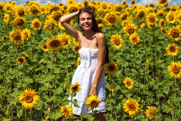 Retrato de uma jovem menina bonita em um campo de girassóis — Fotografia de Stock