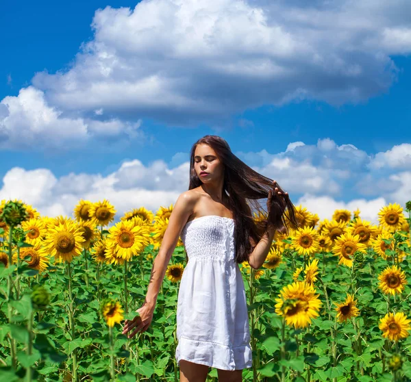 Retrato de una joven hermosa en un campo de girasoles —  Fotos de Stock