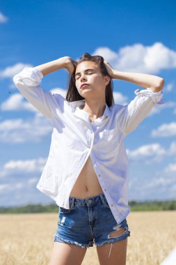 Beyaz gömlek ve mavi kot şort genç esmer kadın 