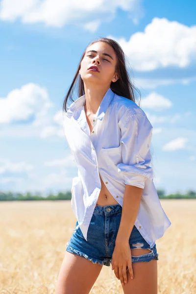 Ung brunett kvinna i vit skjorta och blå jeansshorts — Stockfoto