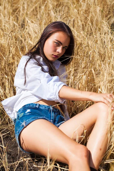 Jovem morena de camisa branca e calções jeans azuis — Fotografia de Stock