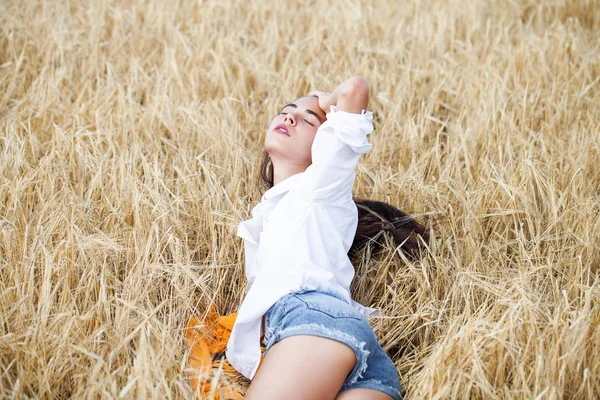 Mujer morena joven en camisa blanca y pantalones vaqueros azules —  Fotos de Stock