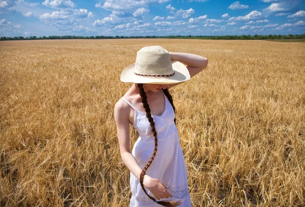 Happy brunette woman in white dress and straw hat walking in a w — Stock Photo, Image