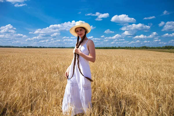 Heureuse femme brune en robe blanche et chapeau de paille marchant dans un w — Photo