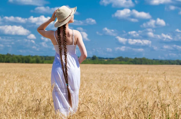 Lycklig brunett kvinna i vit klänning och halm hatt gå i en w — Stockfoto
