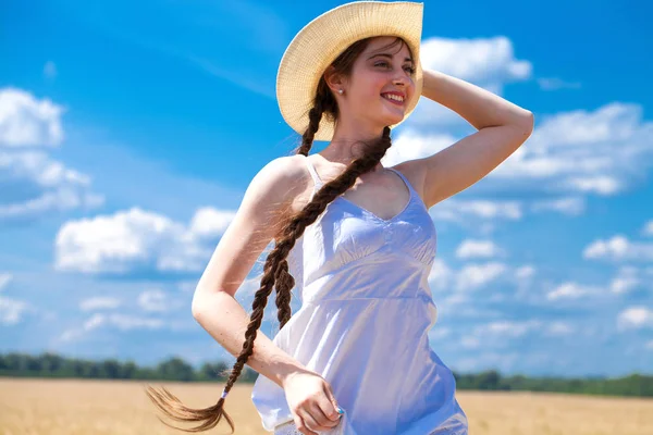 Mujer joven sobre un fondo de campo de trigo dorado — Foto de Stock