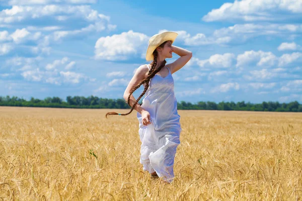 Młoda brunetka Kobieta w białej sukni chodzenie w polu pszenicy — Zdjęcie stockowe
