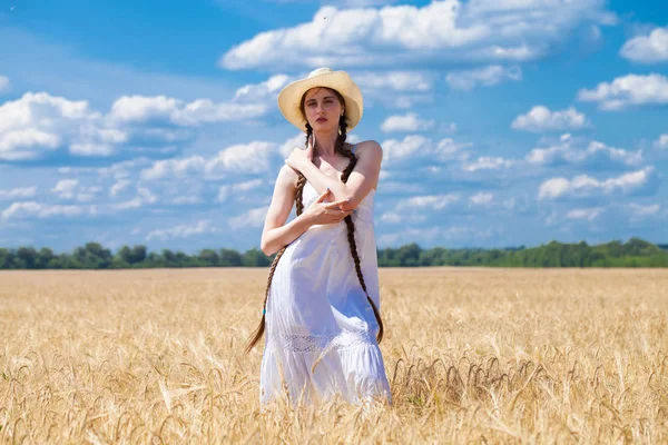 Mujer morena feliz en vestido blanco y sombrero de paja caminando en una w — Foto de Stock