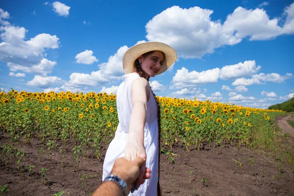 Follow me, young woman holding a guy hand field of sunflowers — Stock Photo, Image