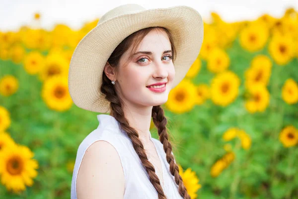 Porträt eines jungen schönen Mädchens in einem Sonnenblumenfeld — Stockfoto