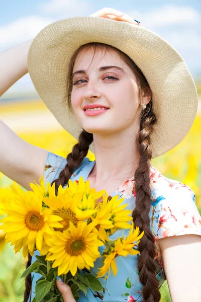 Retrato de una joven hermosa en un campo de girasoles —  Fotos de Stock