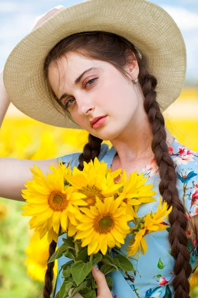 Retrato de una joven hermosa en un campo de girasoles —  Fotos de Stock