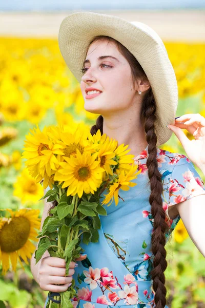 Retrato de uma jovem menina bonita em um campo de girassóis — Fotografia de Stock