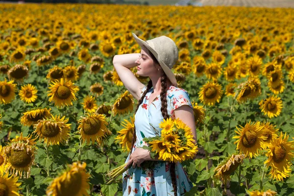Młoda piękna kobieta w słomkowym kapeluszu i z bukietem kwiató — Zdjęcie stockowe