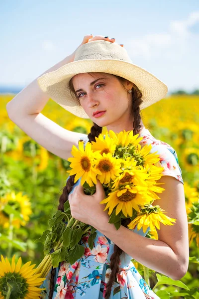 Portrait of a young beautiful girl in a field of sunflowers — Stock Photo, Image