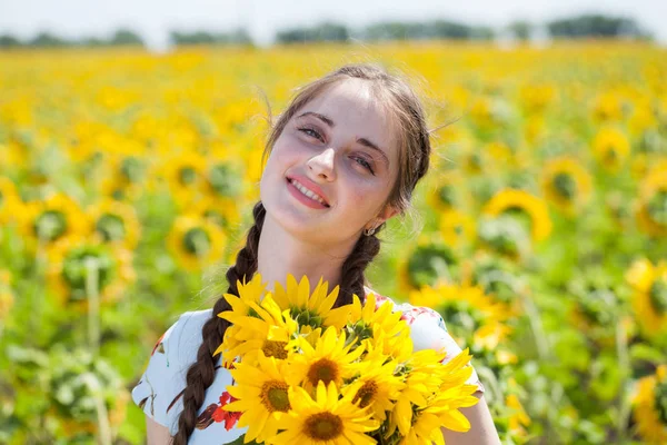 Retrato de uma jovem menina bonita em um campo de girassóis — Fotografia de Stock