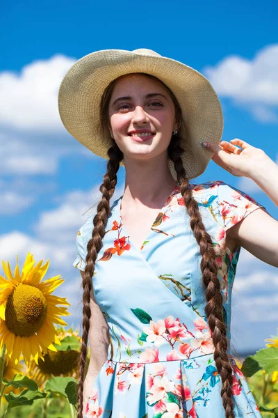 Portret van een jong mooi meisje in een veld van zonnebloemen — Stockfoto