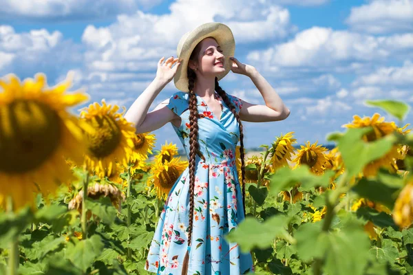 Retrato de una joven hermosa en un campo de girasoles — Foto de Stock