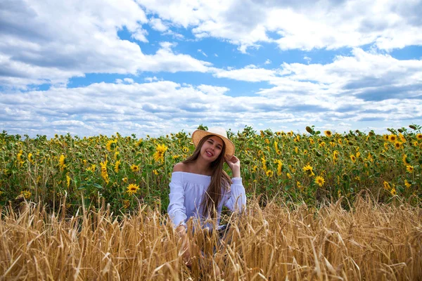 Brunette vrouw in witte blouse zittend op een achtergrond van gouden — Stockfoto