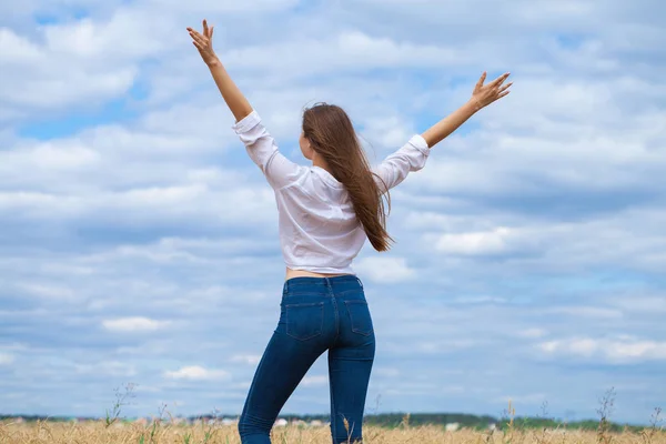 Ung brunett kvinna i vit skjorta och blå jeans — Stockfoto