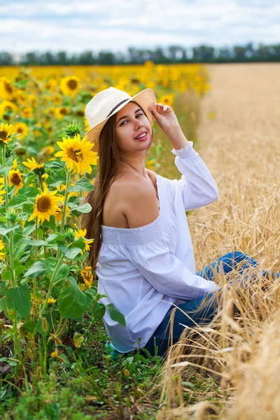 Brunette vrouw in witte blouse zittend op een achtergrond van gouden — Stockfoto