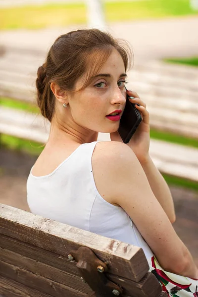 Calling by phone. Beautiful girl in summer dress — Stock Photo, Image