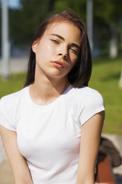 Belle femme brune posant contre le parc d'été, ensoleillé lumineux — Photo