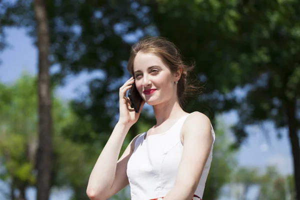 Portret van gelukkige jonge brunette vrouw in jurk praten op de p — Stockfoto
