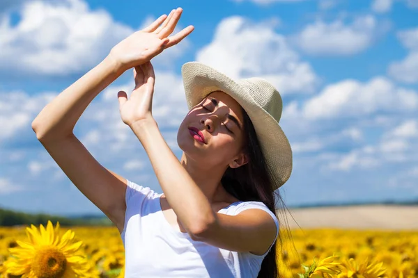 Portret van een jong mooi meisje in een veld van zonnebloemen — Stockfoto