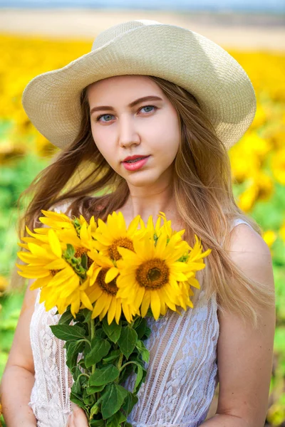 Joven hermosa mujer en un campo de girasoles — Foto de Stock