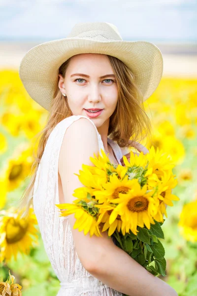 Retrato de uma jovem menina bonita em um campo de girassóis — Fotografia de Stock