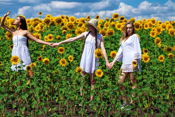 Three young women in white dress posing against the blue sky in — Stock Photo, Image