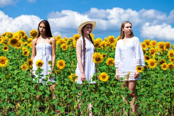 Drei junge Frauen in weißem Kleid posieren vor dem blauen Himmel in — Stockfoto