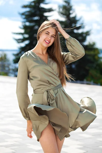 Jovem mulher bonita em vestido verde andando sobre a árvore de verão — Fotografia de Stock