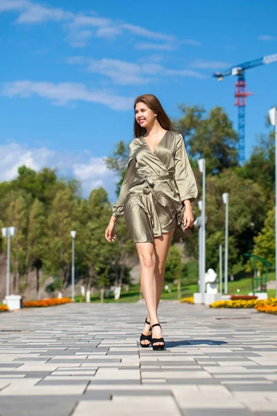 Jovem mulher bonita em vestido verde andando sobre a árvore de verão — Fotografia de Stock