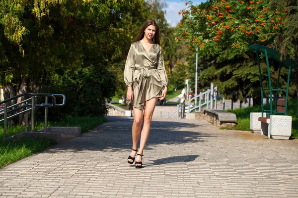 Jovem mulher bonita em vestido verde andando sobre a árvore de verão — Fotografia de Stock