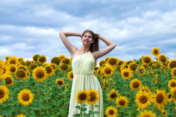 Retrato de uma jovem menina bonita em um campo de girassóis — Fotografia de Stock