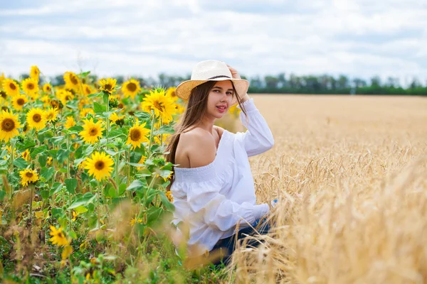 Brunette woman in white blouse sitting on a background of golden — Stock Photo, Image