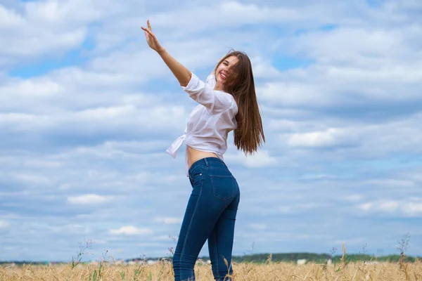 Młoda brunetka Kobieta w białej koszulce i niebieskie dżinsy — Zdjęcie stockowe